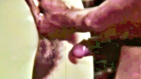 Hairy pussy penetrated by thick pink dildo gripped by hand in closeup