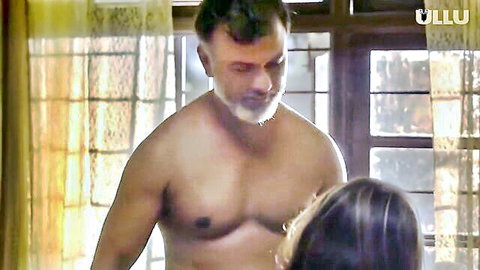 Mature bearded Indian man embraces woman from behind in steamy Ullu web series