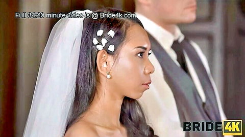 Killa Raketa as elegant Asian bride in white veil and gown beside groom