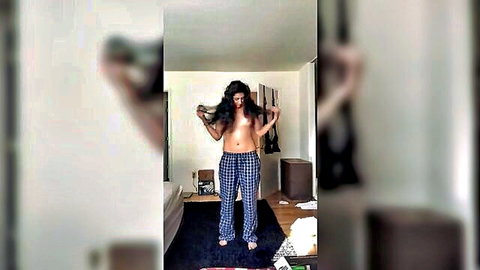 Topless Indian girl lifting long dark hair in plaid pajama pants, cam tease