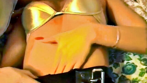 Carmen Shy in gold bikini top with hand caressing her midriff