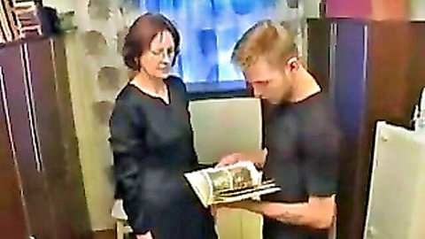 Russian MILF mom in black dress shows book to young lad, taboo mommy scene