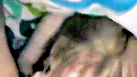 Mystery woman peeking from under colorful blanket in bed, teasing reveal