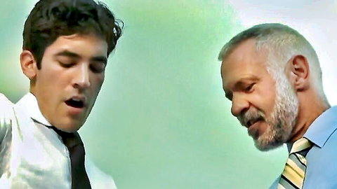 Mature man intimately educating young guy in suits, gay sex scene