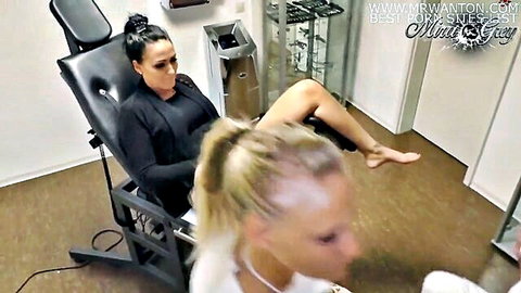 Brunette in black top on exam chair with legs up, blonde in white top nearby, gyno medical scene