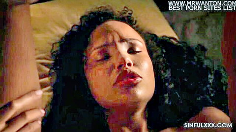 Ecstatic ebony MILF with plump lips moans in passion as lover grips her face on bed