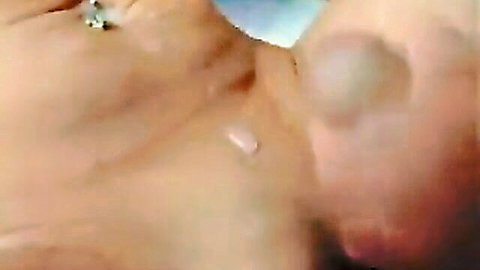 Close-up of young woman's open mouth with thick cum dripping from lips and chin after facial.