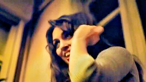 Smiling brunette seductively reaches hand out teasing viewer with playful grin