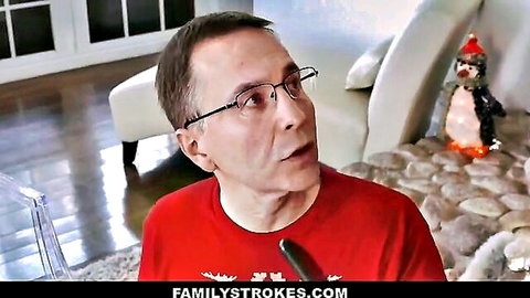 Mature man in glasses and red shirt talks in FamilyStrokes living room with Xmas penguin toy.