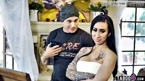 Tattooed brunette MILF in white towel teases smiling guy holding phone in taboo indoor scene