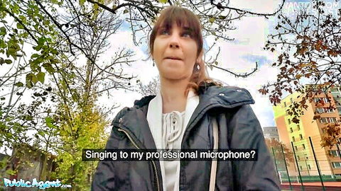 Shy brunette in Public Agent pickup, singing to microphone outdoors