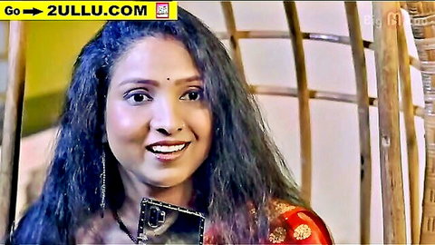 Sexy Indian woman in red saree smiling seductively while holding black phone