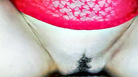 Hairy pussy exposed under pulled-aside red lace panties on white thighs
