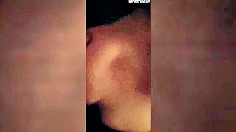 Blurry closeup of woman's profile and ear in low-quality homemade sex video