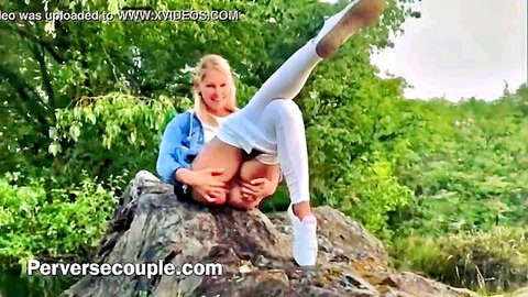 Blonde babe in stockings spreads legs for outdoor pee on rock