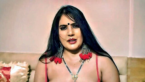 Busty Indian woman in red bra showing deep cleavage with big red earrings and bindi