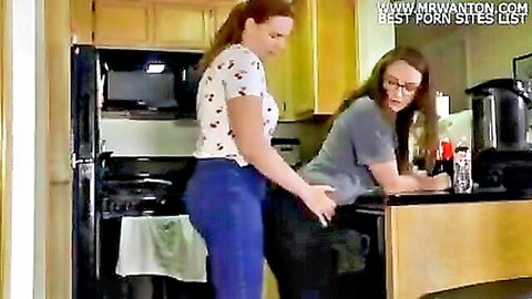 Redhead in jeans humps brunette's ass over counter in kitchen
