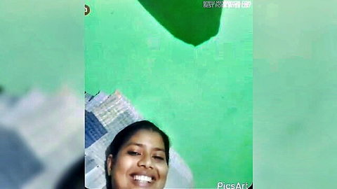 Nisha smiling in colorful sari, lying on bed, amateur Indian beauty