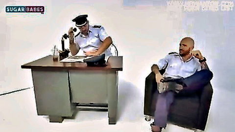 Two Greek police officers in uniforms during intense gay office encounter