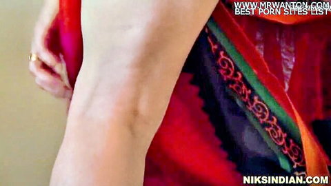 Sexy Indian woman lifting red saree to tease smooth brown thigh and leg