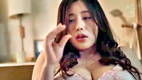 Busty Asian MILF in pink lace bra teases with fingers near open wet mouth and huge cleavage