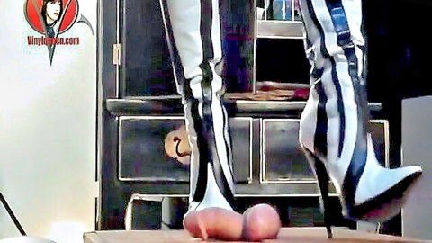 Dominatrix in striped boots tramples naked slave's cock and balls BDSM fetish