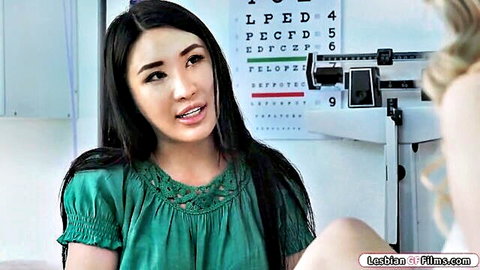 Asian nurse in green top massaging blonde patient up to tits in clinic