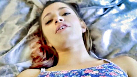 Seductive step sis in floral dress lying on bed, teasing gaze