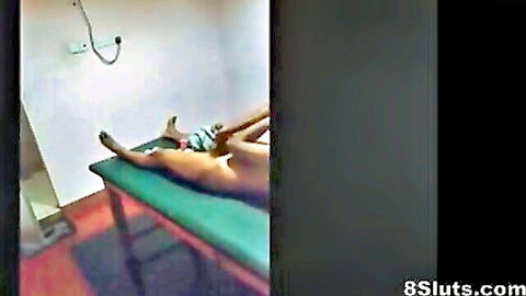 Naked South Asian MILF lies face down nude on green massage table exposing bare ass in spa