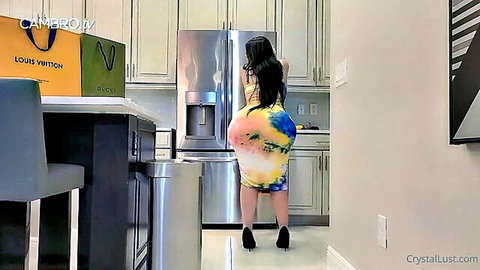 Thick brunette MILF in tight colorful dress bends over kitchen fridge showing massive round ass