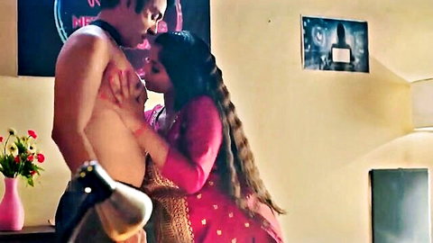 Indian beauty in pink dress embraces shirtless boss intimately