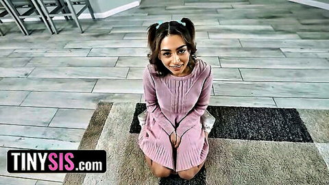 Vanessa Moon kneels smiling in pink dress, pigtails and glasses