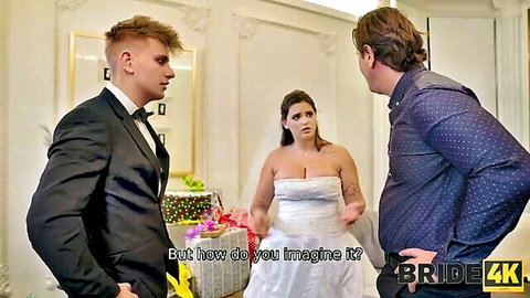 Curvy brunette bride in strapless wedding dress stands between suited groom and older stud at wedding