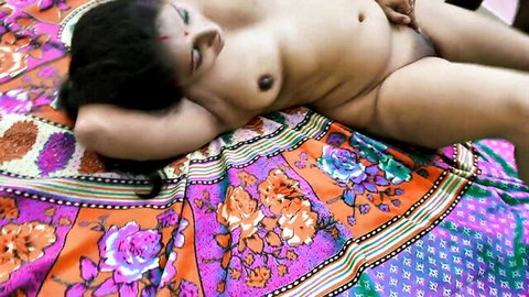Nude Desi stepmom with long black hair fondles her pussy lying on bed
