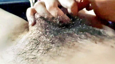 Red-nailed fingers spreading and fingering hairy wet pussy closeup