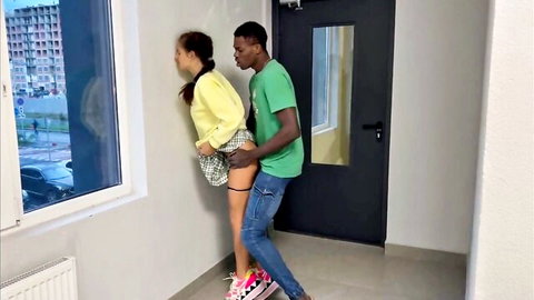 Asian woman in skirt dominated against stairwell wall by black man