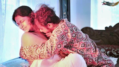 Busty Indian woman topless passionately kissed on neck by lover in steamy bedroom embrace