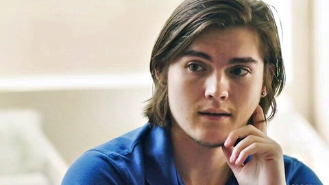 Alex Coal in thoughtful blue shirt pose, tutoring scene with Sophia Burns