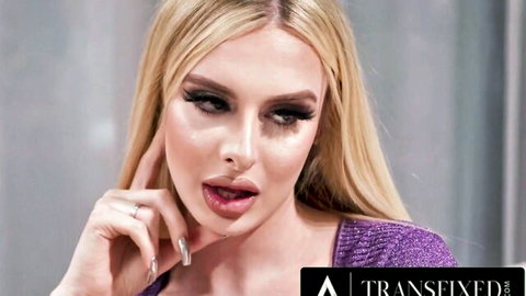 Hot blonde cross-dressing woman seductively posing with tongue out in purple top