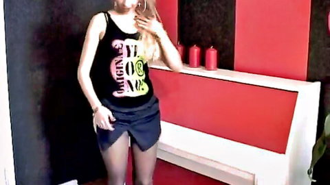 Blonde amateur in tank top and mini skirt poses seductively in stockings