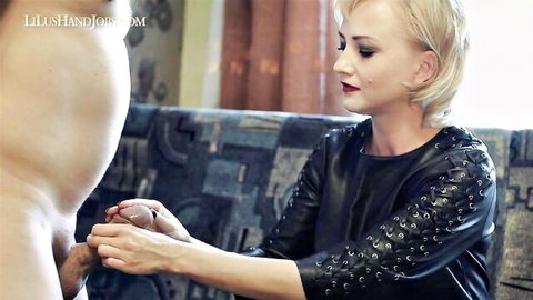 Blonde woman in studded leather top gives handjob stroking man's thick erect cock with both hands