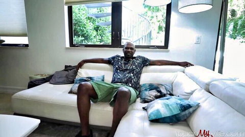 Relaxed muscular black man lounging casually, from busty wife cum-swallowing video