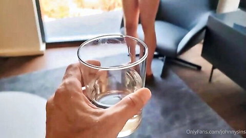 POV of curvy fair-skinned babe's exposed ass and wet pussy with leg up on chair while hand holds glass of water