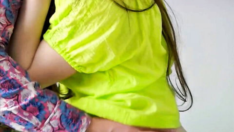 Skinny blonde in sheer green top passionately embraced and kissed on neck by brunette in flowery blouse