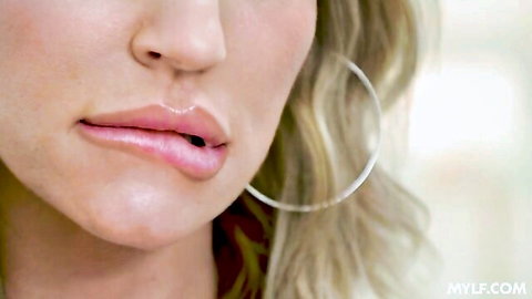 Blonde MILF with glossy lips and hoop earrings seductively pouting