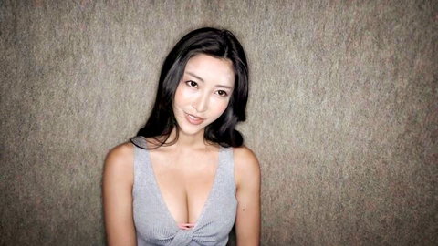 Emiri Momota in sexy gray dress with deep cleavage, smiling seductively