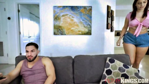 Skinny brunette teen in pink bralette and tiny denim shorts teases Latino guy on couch