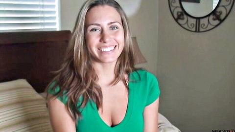 Renna Ryann smiling with cleavage in green low-cut top