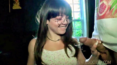 Petite brunette teen with glasses smiles at massive BBC cock held near her face