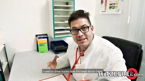 Handsome trucker-turned head doctor in glasses and white coat smiling in medical office